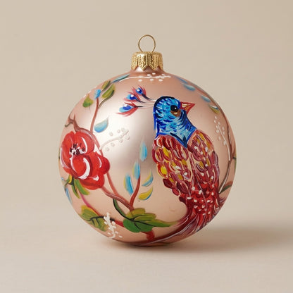 Palla di Natale Ø 10 cm dipinta a mano: uccello multicolore e fiori su fondo rosa