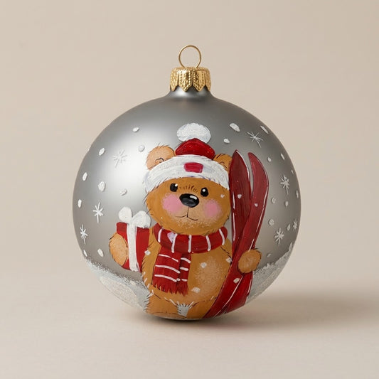 Palla di Natale Ø 10 cm dipinta a mano: orsetto con gli sci e regalo su fondo argento