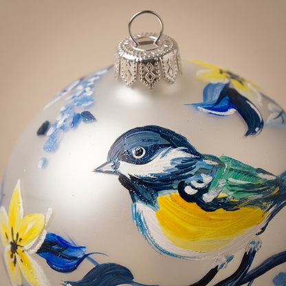 Dettaglio del decoro dipinto a pennello: uccellino blu e giallo su ramo con fiori blu