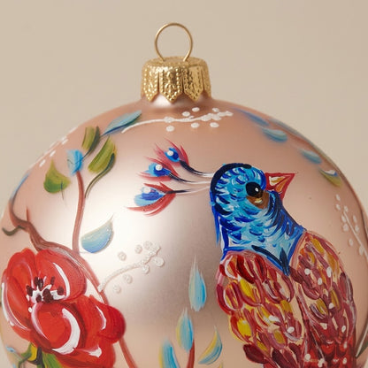 Dettaglio del decoro dipinto a pennello: uccello multicolore e fiori su fondo rosa