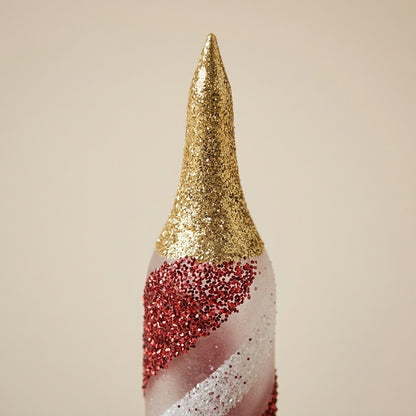 Detail of the gold glitter tip of the red and white candle ornament