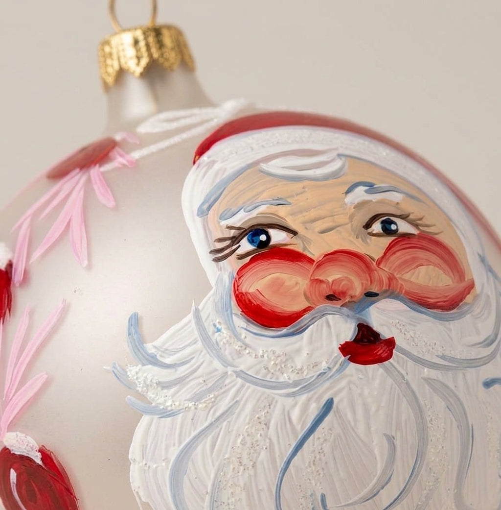 Dettaglio del decoro dipinto a pennello: volto di Babbo Natale tra fiori rosa su fondo bianco