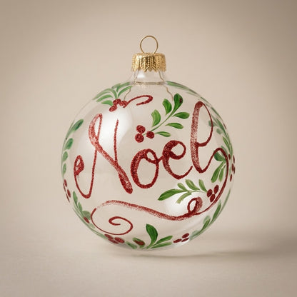 Palla di Natale Ø 10 cm dipinta a mano: scritta Noël in glitter rosso con foglie verdi su vetro trasparente