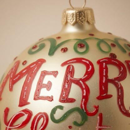 Dettaglio del decoro dipinto a pennello: scritta Merry Christmas rossa su fondo avorio